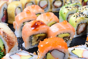 Traditional colorful suhi, cream cheese, salmon, caviar, rool sishi crunch, sesame seeds and sauce