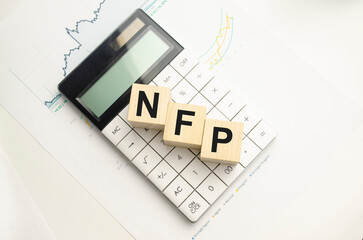 Word NFP. Wooden small cubes with letters isolated on blue background with copy space available. Business Concept image.