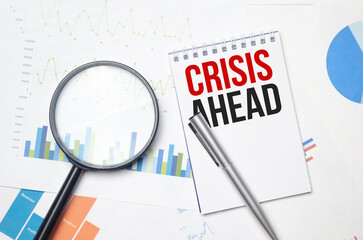 CRISIS AHEAD text written on notebook on a chart with keyboard and planning