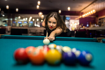 pretty caucasian woman playing snooker at pub