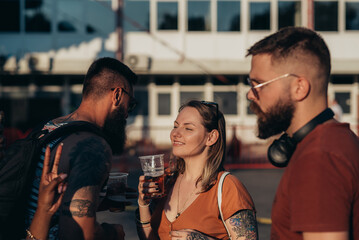 Group of friends drinking beer and having fun at music festival