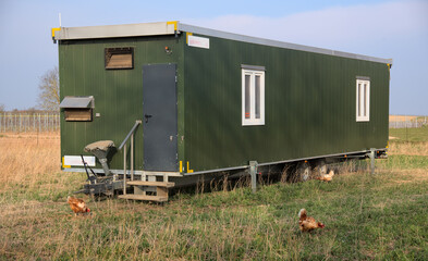 Mobile chicken coop trailer in a field 