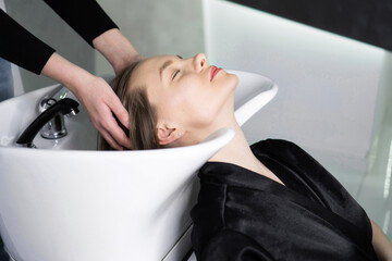 Hairdresser washing a client's head in a salon