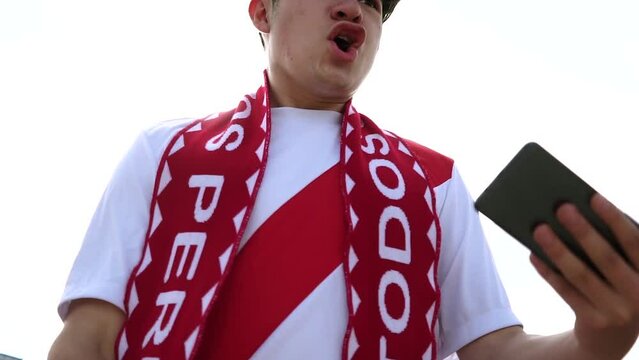 Fan de Per&uacute; celebrando un gol con su celular. Fan de la selecci&oacute;n de futbol de Per&uacute; celebrando goles. Concepto de Futbol. Copa del mundo.