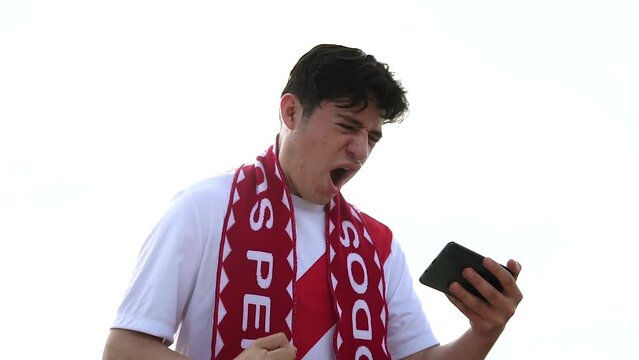 Fan de Per&uacute; celebrando un gol con su celular. Fan de la selecci&oacute;n de futbol de Per&uacute; celebrando goles. Concepto de Futbol. Copa del mundo.