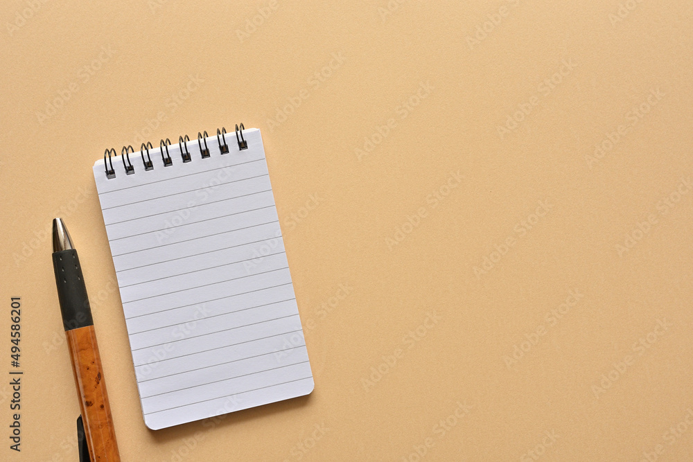 Poster a notebook and pen in a simple composition. copy space available.