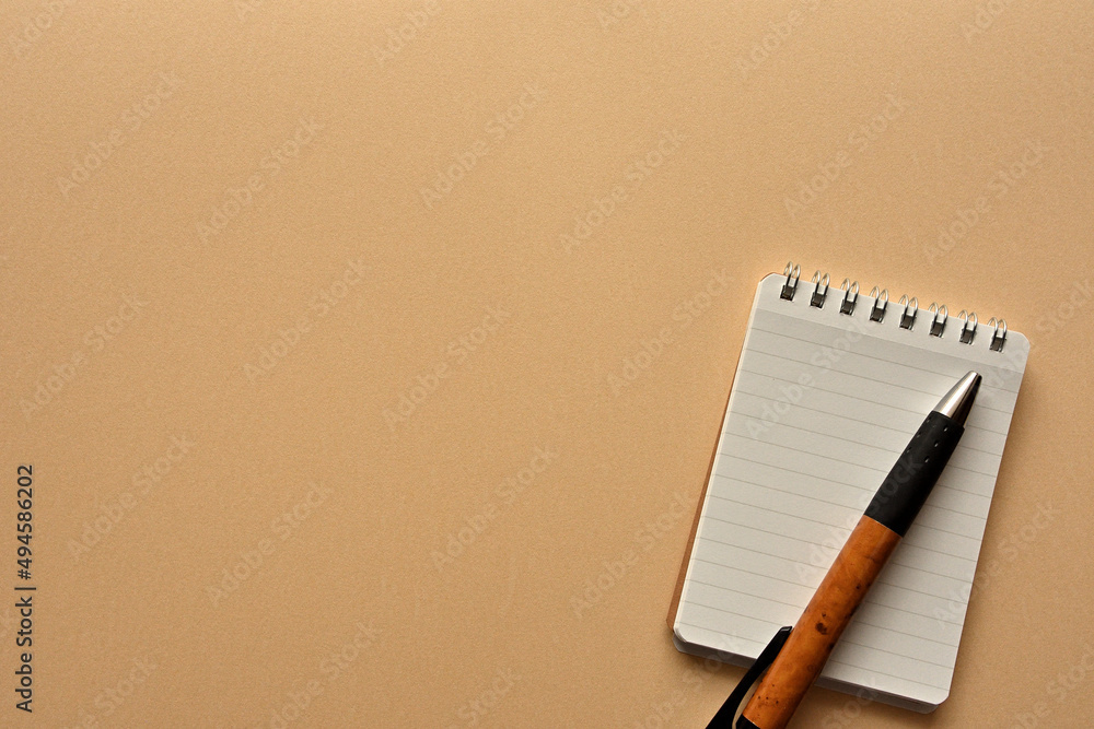Poster a notebook and pen in a simple composition. copy space available.