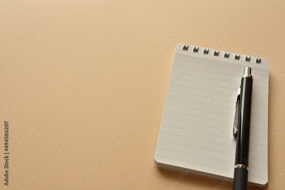 Poster a notebook and pen in a simple composition. copy space available.