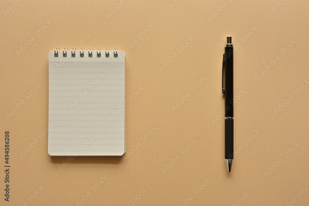 Poster a notebook and pen in a simple composition. copy space available.