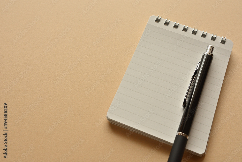 Poster a notebook and pen in a simple composition. copy space available.