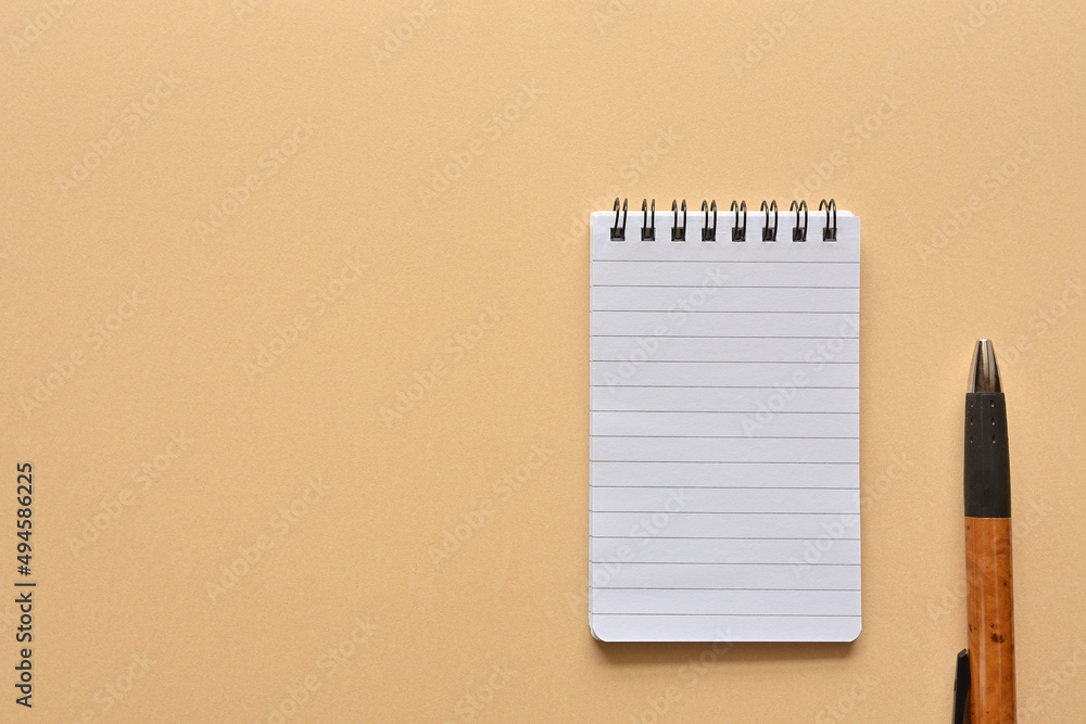 Poster a notebook and pen in a simple composition. copy space available.