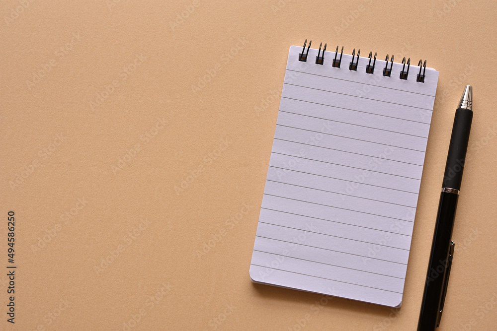 Poster a notebook and pen in a simple composition. copy space available.