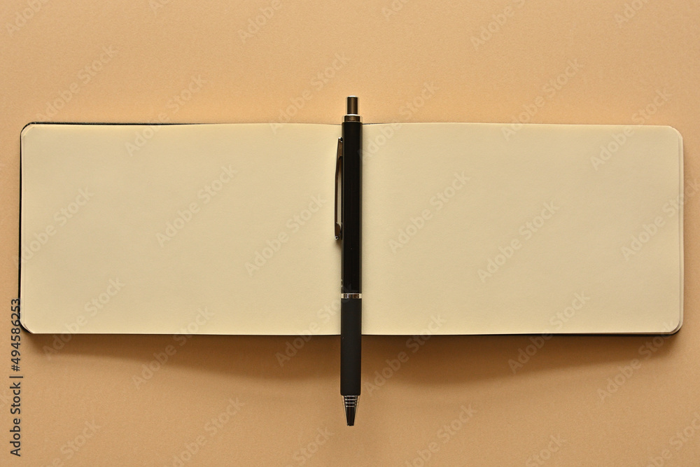 Poster a notebook and pen in a simple composition. copy space available.