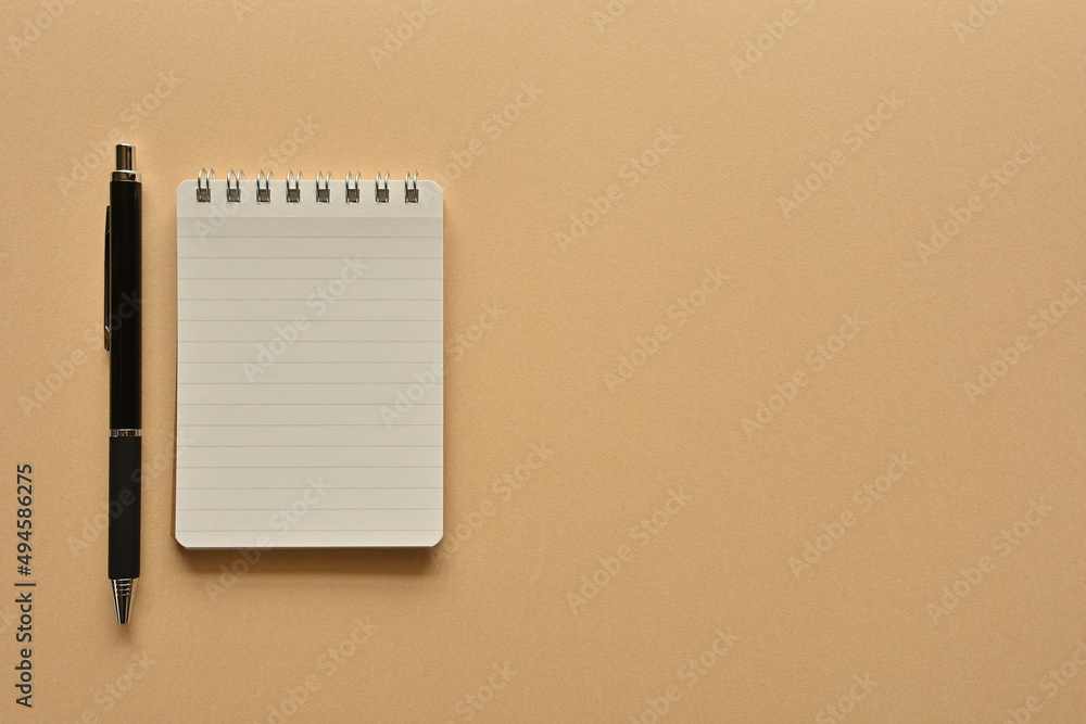 Poster a notebook and pen in a simple composition. copy space available.