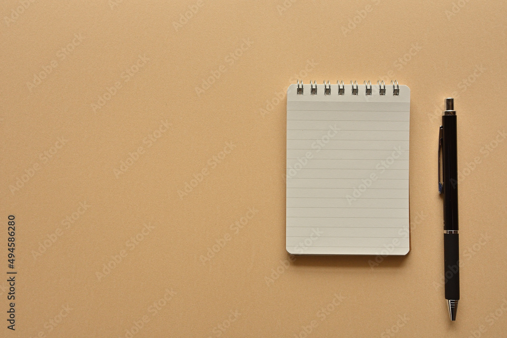Poster a notebook and pen in a simple composition. copy space available.