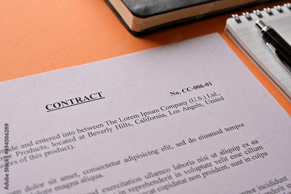 Poster the dummy contract is placed there along with a pen and a notebook on orange background.