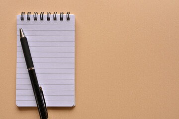 A notebook and pen in a simple composition. Copy space available.
