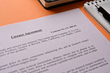 The dummy Licence Agreement is placed there along with a pen and a notebook on orange Background.
