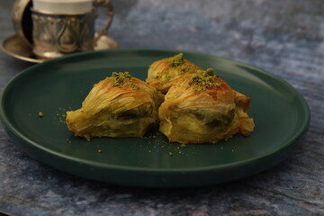 Pistachio baklava on a dark green plate