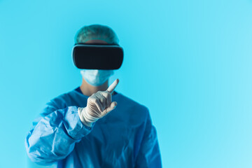 Healthcare worker in protective suit with VR glasses performing research in virtual reality simulation. Blue background. High quality photo