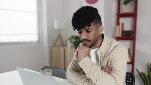 Latin american young man having a video calll on laptop from home. High quality 4k footage
