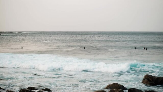 Serfers on a ocean wave on sunset, Atlantic Ocean