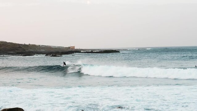 Serfers on a ocean wave on sunset, Atlantic Ocean