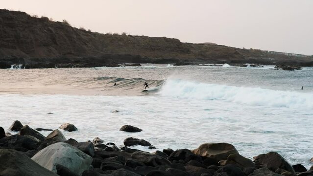 Serfers on a ocean wave on sunset, Atlantic Ocean