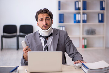 Fototapeta premium Young male employee after car accident working in the office