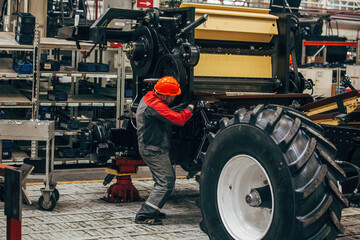 Industrial workers assembles agricultural harvester in workshop