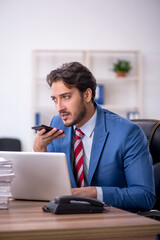 Obraz premium Young male employee and too much work in the office