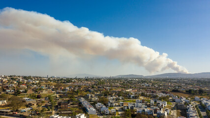 Bosque urbano incendio forestal en ciudad humo y nubes blancas por toda la ciudad contaminación...