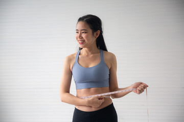 young Asian woman measure a body proportions, health fitness to slim body and diet concept, female...
