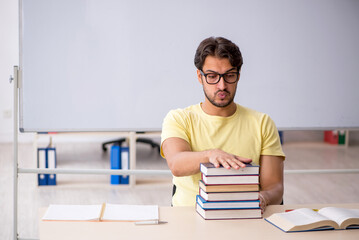 Young male student preparing for exams in the classroom