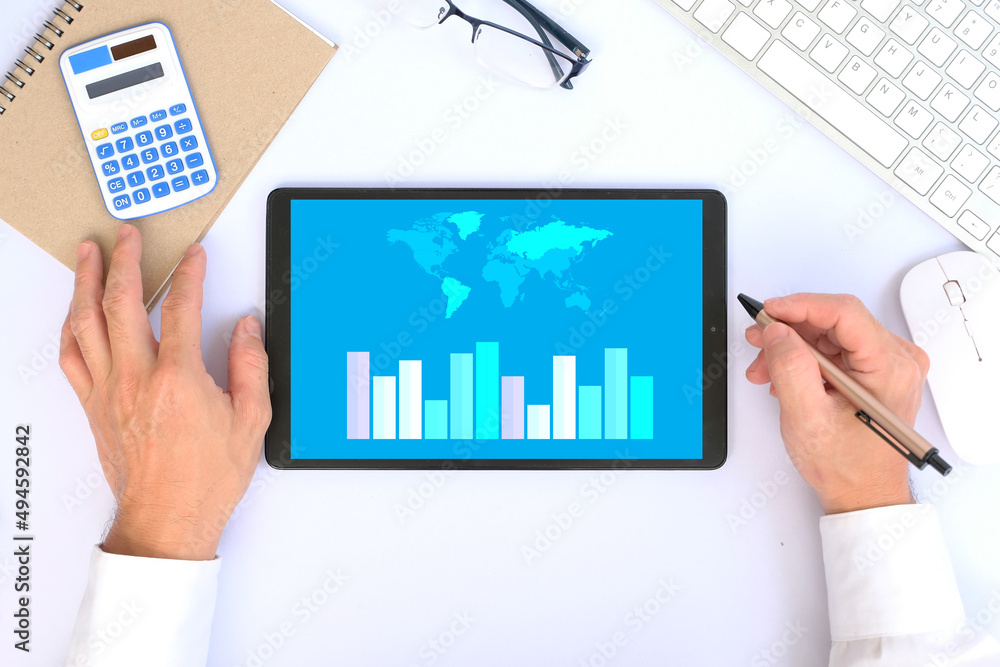 Poster top view hand working a tablet with growing virtual hologram of statistics, graph and chart.chart gr