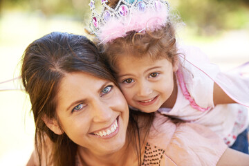 My little princess. Cropped shot of a beautiful woman and her daughter playing outdoors.