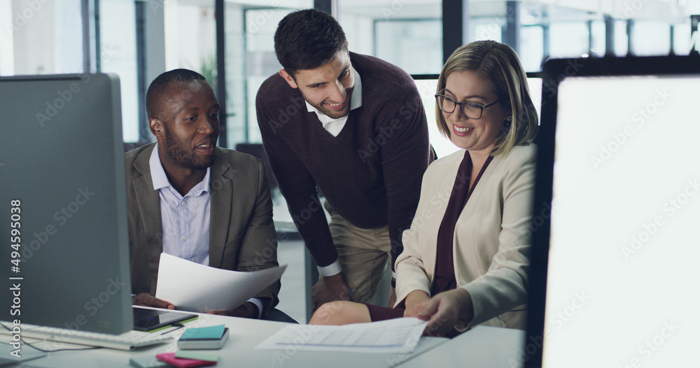 Poster working towards common goals. cropped shot of three businesspeople discussing some paperwork in thei