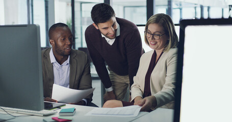 Working towards common goals. Cropped shot of three businesspeople discussing some paperwork in...