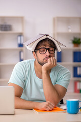 Young male student preparing for exams in the classroom