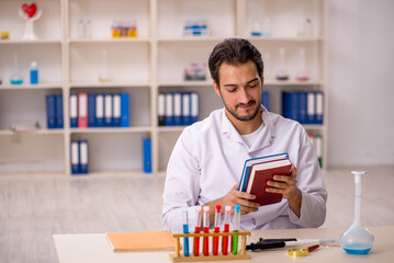 Young male chemist working at the lab