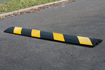Black and yellow bright speed bumps on the road