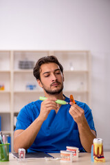 Young male dentist working in the clinic