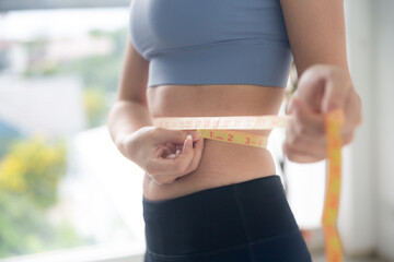 young Asian woman measure body proportions, health fitness to slim body concept