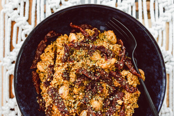 vegan couscous with butter beans topped with sundried tomatoes and Moroccan spices, healthy plant-based food