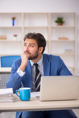 Young male employee and too much work in the office