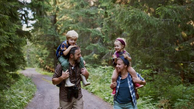 Family with small children walking outdoors in summer nature.