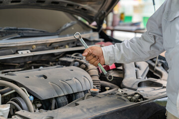 Car technician holding the wrench promt to fixed.