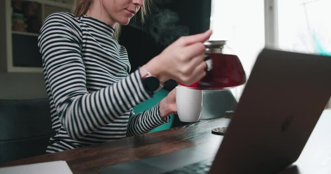 Girl is pouring tea into cup