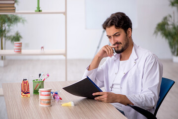 Young male dentist working in the clinic