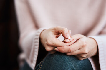 The hands say what the heart feels. Cropped shot of a woman sitting on a sofa and feeling anxious.